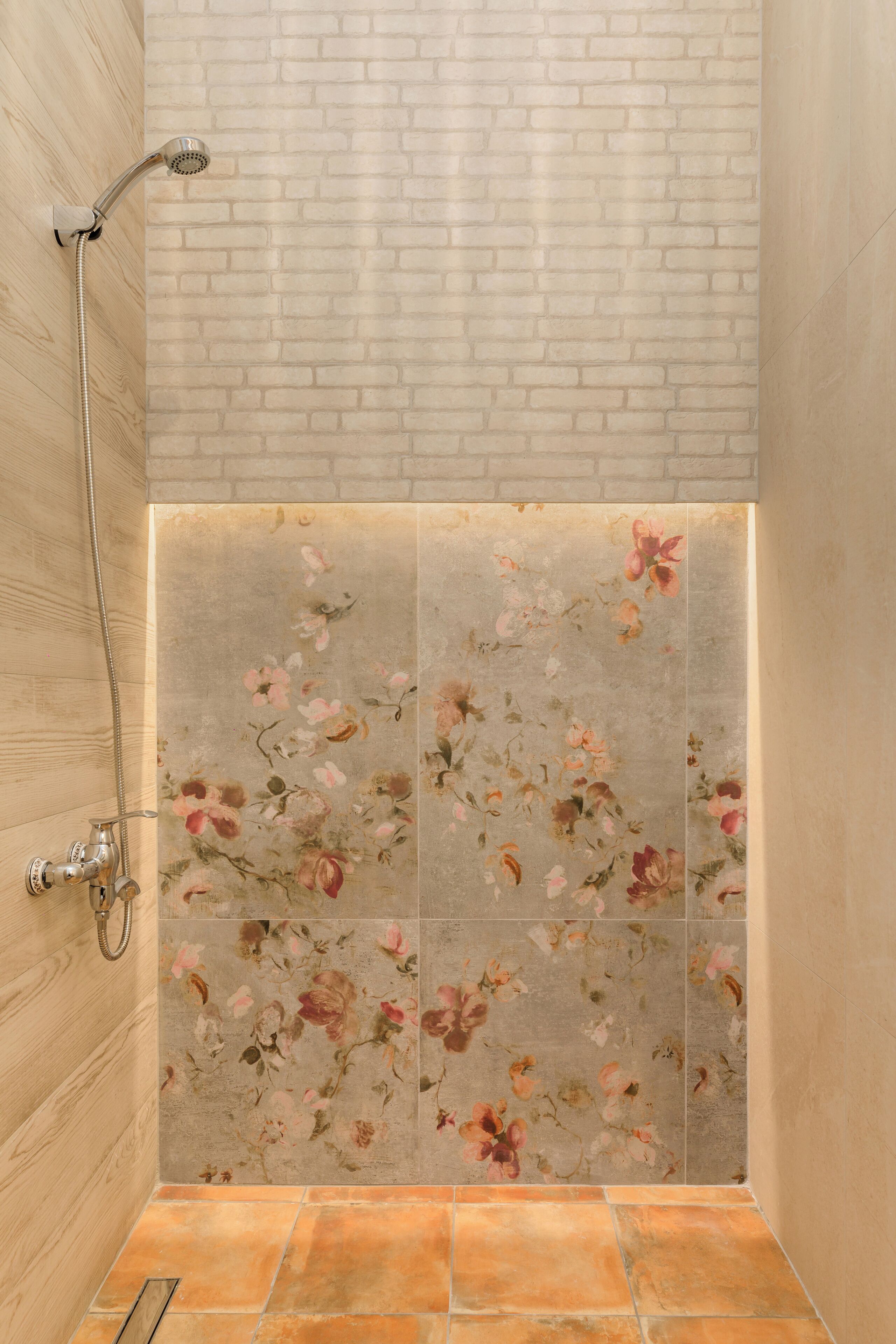 A shower with a wooden wall and a floral tile design.
