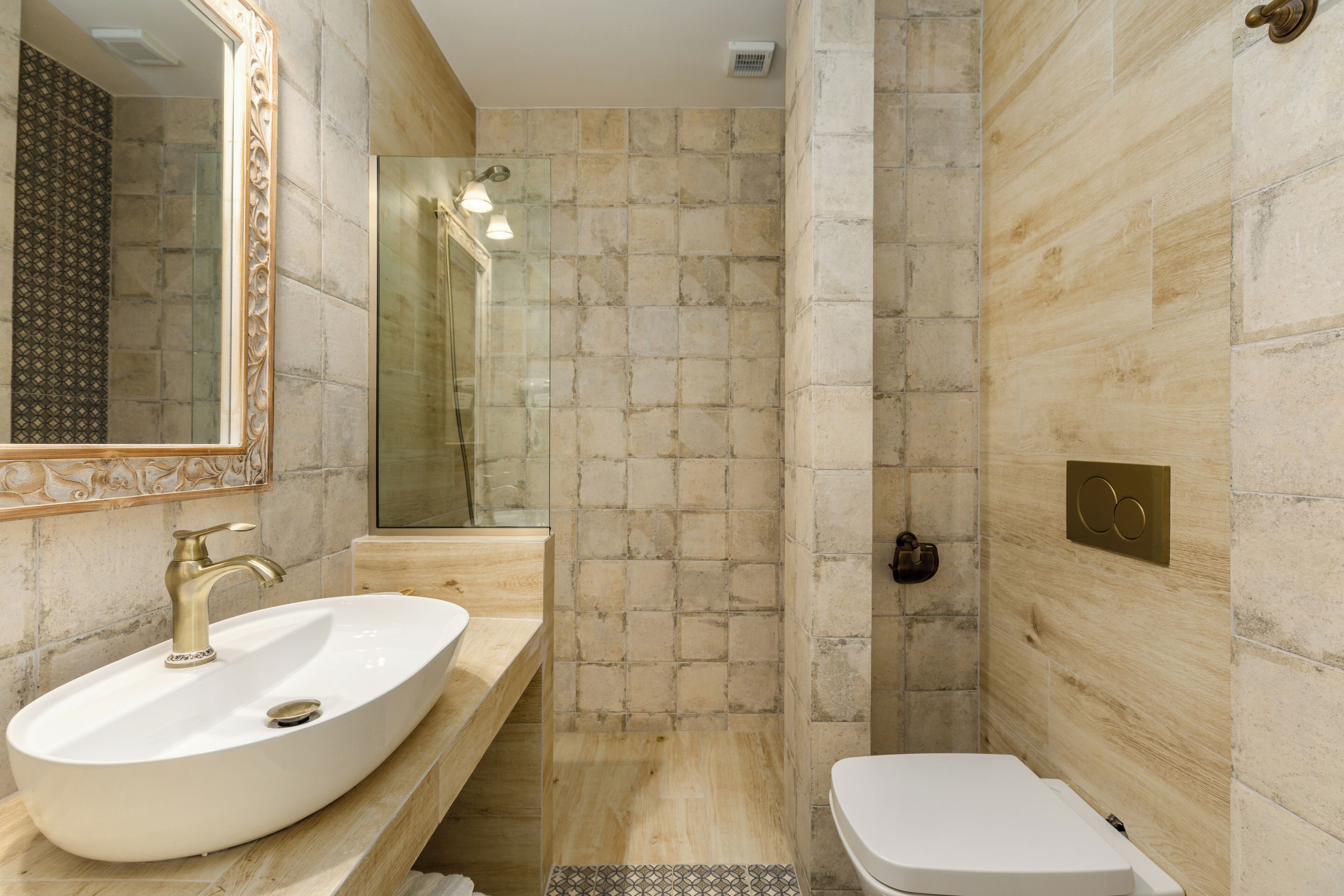 Une salle de bain avec un grand lavabo ovale, un miroir, une douche et des toilettes.