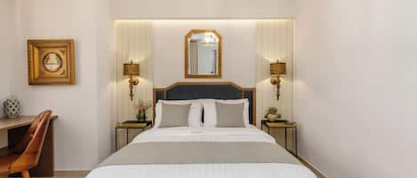 A hotel room with a large bed, bedside tables, a desk, and a chair.