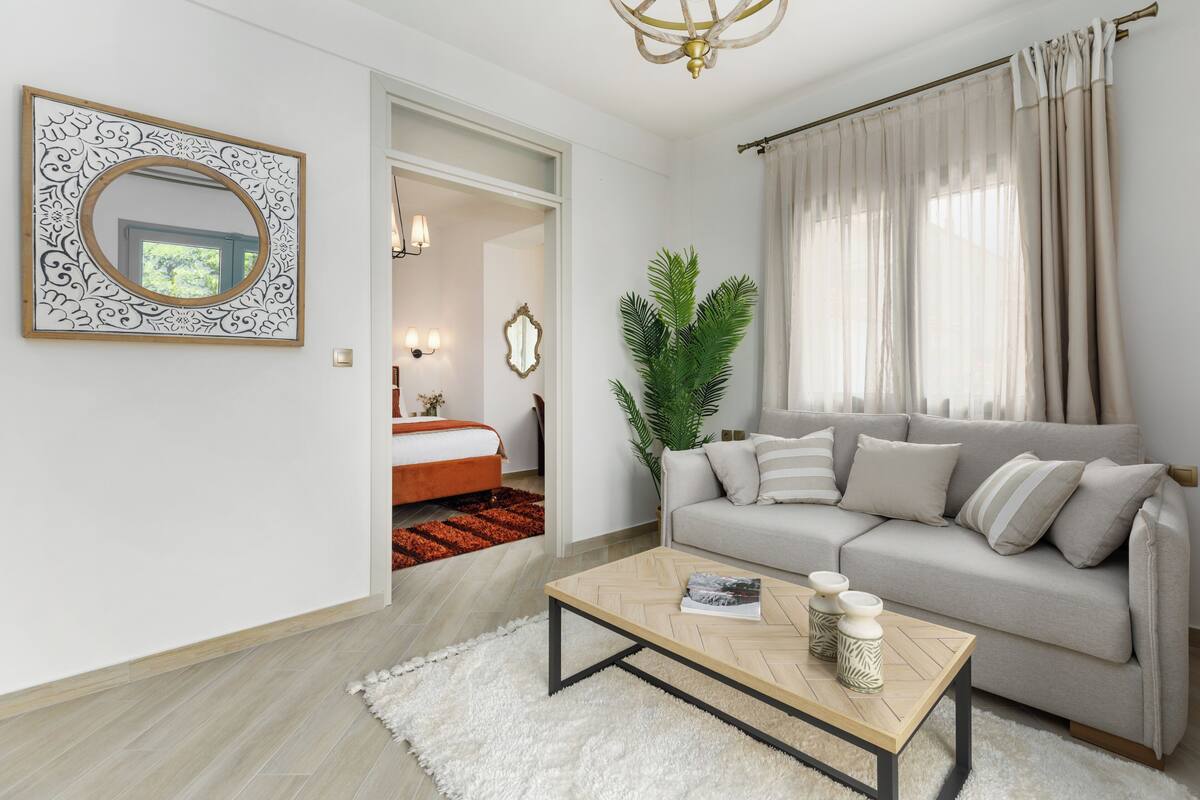 A modern living room with a sofa, coffee table, and a mirror.
