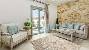 Un salon comprenant un canapé, un fauteuil, une table basse et un tapis à motifs.