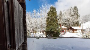 A snowy landscape with a wooden cabin and a snow-covered yard. - Rustic Modern Studio • Ski-in, Ski-out • King Bed (Wengen)