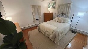 A bedroom with a bed, a nightstand, a lamp, and a ceiling fan. - 1 mile to beach The Point House (Point Pleasant Beach)