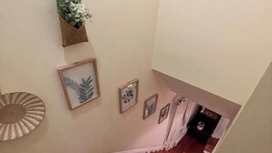 A staircase with wooden flooring leading to a landing. There are framed pictures and a small plant on the wall. - 1 mile to beach The Point House (Point Pleasant Beach)