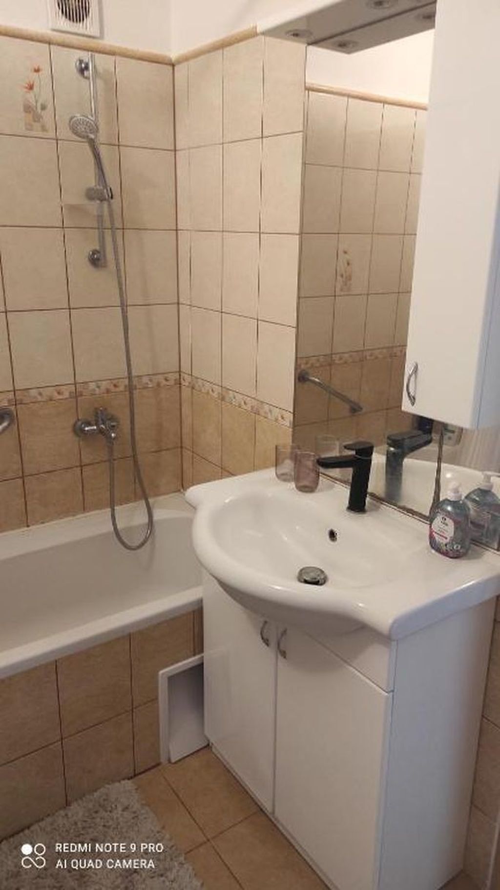 Un baño con bañera, lavamanos y espejo.