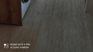 Eine moderne Küche mit weißen Schränken, einer Mikrowelle, einem Toaster, einem Herd und einer Waschmaschine.