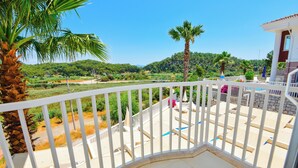 A balcony with a white railing, overlooking a lush green landscape with palm trees and a clear blue sky. - Beautiful Detached Villa With Private Pool And Stunning Views,Walkable to Town. (Dalanan)
