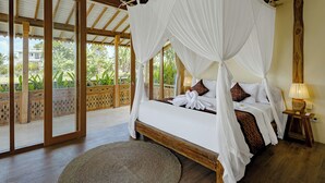 A four-poster canopy bed with white linens and brown accents, a wooden floor, and a view of greenery outside. - Oemah Cinta Ubud Villa (Tegallalang)