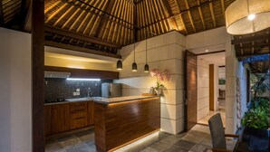 A modern kitchen with a central island, wooden cabinets, and a tiled backsplash.
