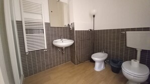 Uma casa de banho com lavatório, sanita e espelho.