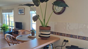 Eine Küche mit Kaffeemaschine, Wasserkocher und einem Blumentopf auf der Arbeitsfläche.