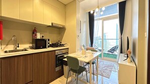 Une cuisine moderne avec des meubles en bois, une cuisinière à gaz et un coin repas comprenant une table et des chaises.
