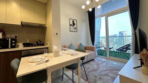 Une cuisine moderne avec un coin repas, un canapé et un balcon offrant une vue sur la ville.