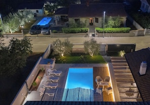 Ein Poolbereich auf dem Dach mit Liegestühlen und einer Holzterrasse.