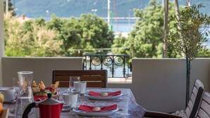 A table set for two with plates, glasses, and a red napkin. - House Kaliope (Zadar)