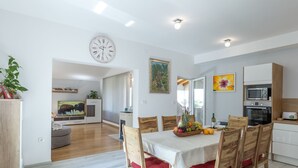 A modern kitchen with a microwave, oven, and a fruit bowl on the counter. - House Kaliope (Zadar)