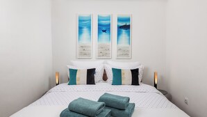 A neatly made bed with a white and teal color scheme, two pillows, and a set of folded towels. - Sorgenfrei 2-bedroom apartment in Rovinj Old Town (Rovinj)