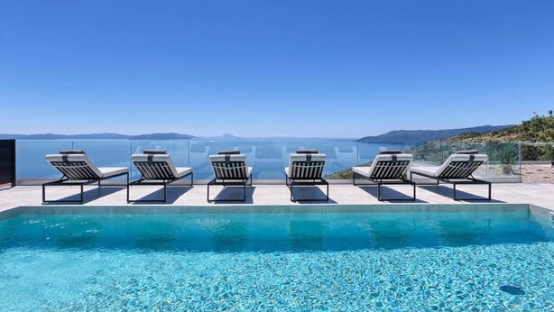 A pool with clear blue water and a view of the sea and mountains. - Villa Ultima (Labin)