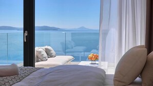 A bedroom with a large window overlooking a body of water and distant mountains. - Villa Ultima (Labin)