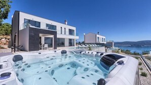A modern two-story house with a large outdoor hot tub and a view of the sea. - Villa Ultima (Labin)