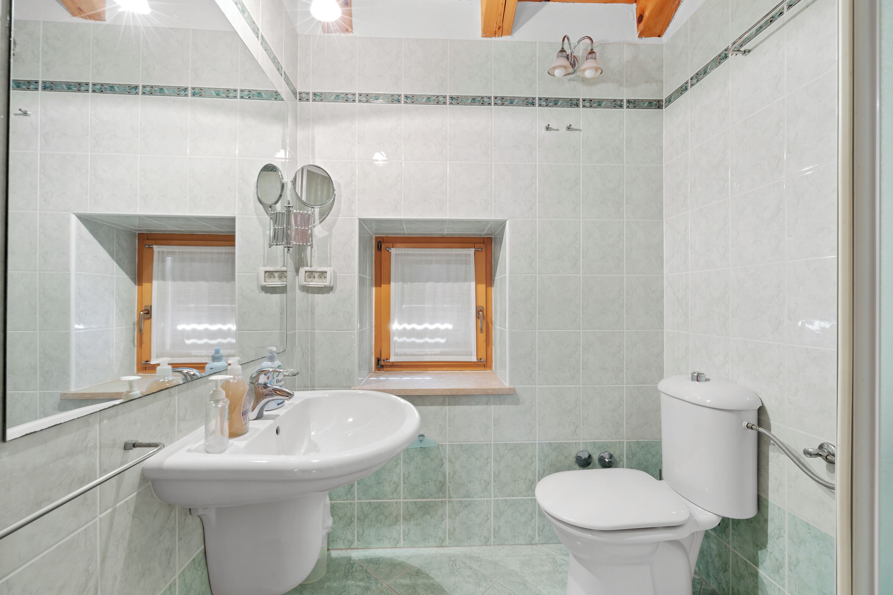 Une salle de bain avec un lavabo, un miroir et des toilettes.