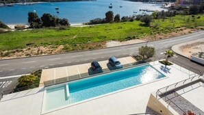 A swimming pool with a view of the sea and a road. - Luxury Apartment Anto (Medulin)