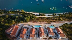 A coastal hotel with multiple buildings, a marina with boats, and a clear view of the sea. - Luxury Apartment Anto (Medulin)