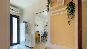 Una cocina moderna con armarios blancos, horno empotrado y comedor con sillas amarillas.