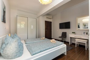 A modern bedroom with a bed, a desk, a chair, and a TV. - Villa Cvek (Kanfanar)