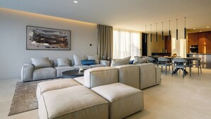 A modern living room with a sectional sofa, a coffee table, and a dining area with chairs and a table. - Villa Z6 - Luxury Retreat in the Heart of Rovinj (Rovinj)