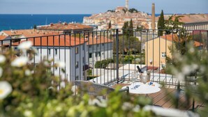 A balcony with a table and chairs, overlooking a coastal cityscape with historic buildings and a prominent tower. - Villa Z6 - Luxury Retreat in the Heart of Rovinj (Rovinj)