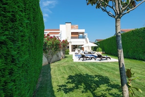A modern house with a well-maintained lawn, outdoor seating area, and a clear blue sky. - Villa Allegra (Tar-Vabriga)