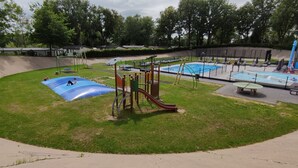 A playground with a slide, swings, and a small pool. - Boshuisje Wageningen (Wageningen)