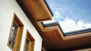 Un coin d’immeuble avec des poutres en bois et des fenêtres.