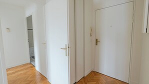 Un pasillo con puertas blancas y suelo de madera.