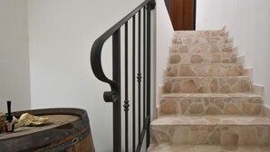 A staircase with stone steps and a black metal railing. - Casa Carlà by Rentbeat (Surbo)
