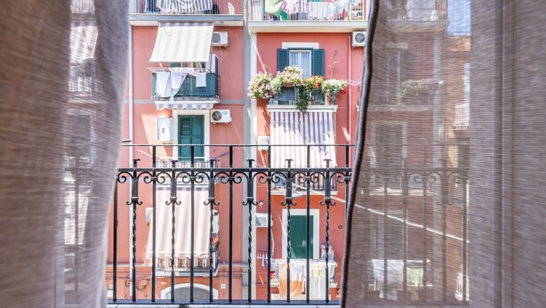 Un immeuble à plusieurs étages doté de balcons, de climatiseurs et de linge séchant sur des cordes à linge.