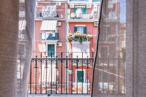 A multi-story building with balconies, air conditioning units, and laundry hanging on lines. - The Balcony by Rentbeat (Bari)