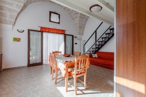 A dining area with a table, chairs, and a staircase.
