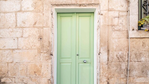 A green door set in a stone wall. - Il Vico 113 Ostuni by Rentbeat (Casoria)