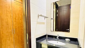 A bathroom with a wooden cabinet, a black sink, and a mirror. - OYO 1233 Home Elite 1 Residence Sports City, Dubai (Dubai)