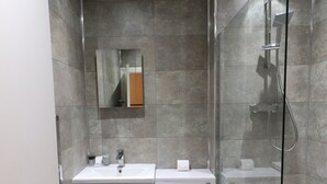 A modern bathroom with a shower, toilet, and sink. - St George's Lodge (Woking)