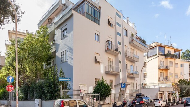A multi-story residential building with balconies, a parking sign, and a stop sign. - Casa Giancarlo by Rentbeat (Roma)