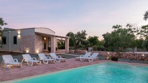 A poolside area with lounge chairs and a pool.