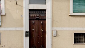 En brun trædør med en messingknop, en lille skilt over døren, og tallet '13' på væggen til venstre.
