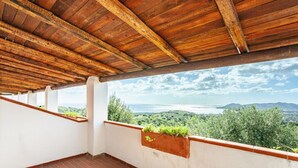 A covered balcony with a view of a coastal landscape. - Comino Alto - Appartamento 5 by Rentbeat (Siniscola)