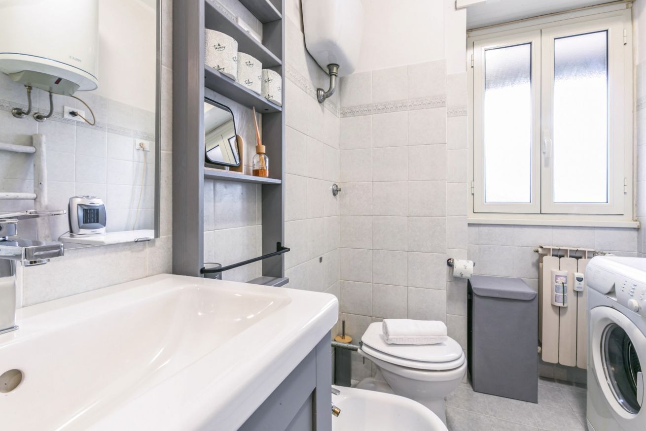 Un bagno moderno con vasca, water e lavatrice.