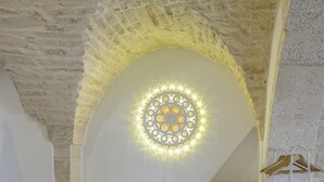 A room with a stone ceiling and a decorative light fixture.