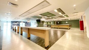 Un vestíbul ampli amb una recepció central, diverses zones d'estar i un disseny de sostre modern.