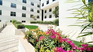Edifici modern amb un pati que presenta una varietat de plantes i flors.